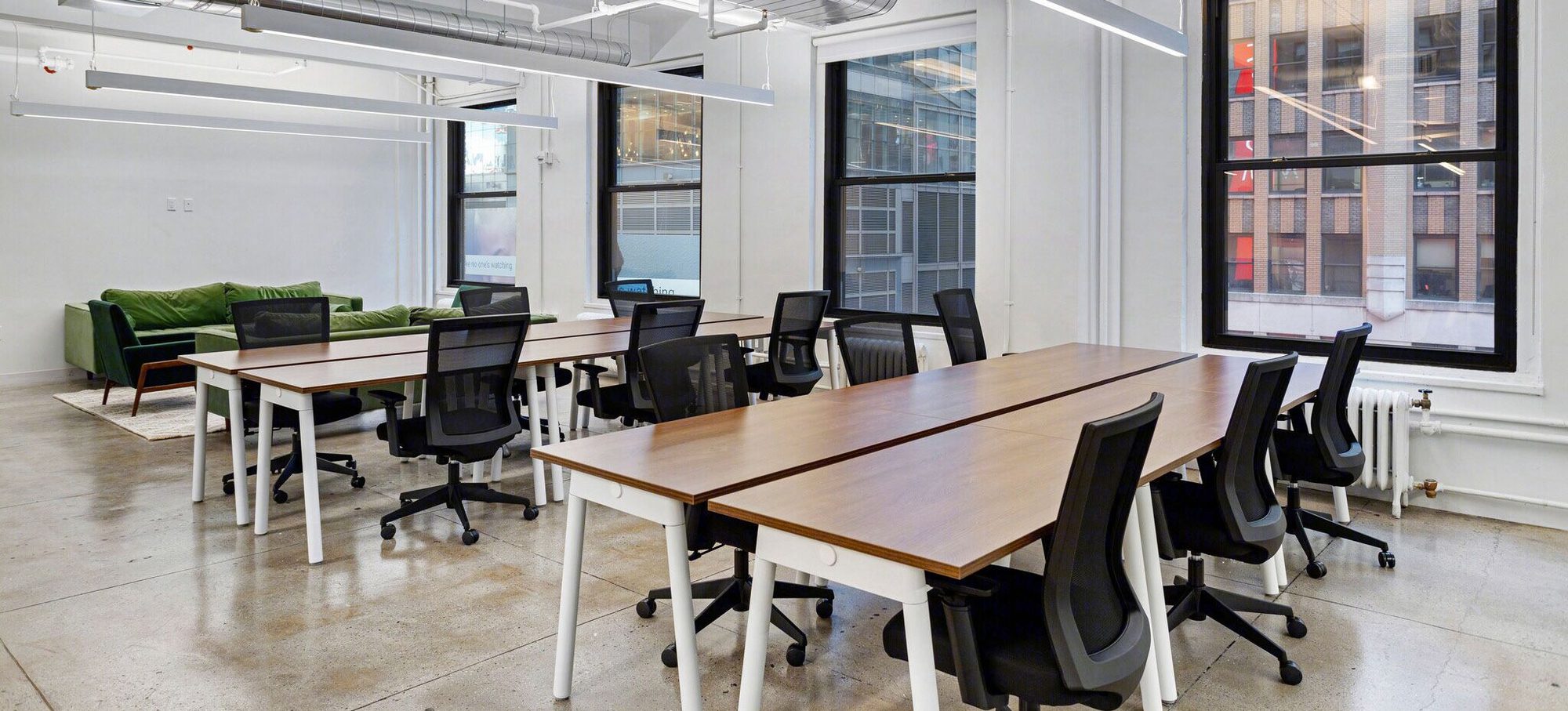 Open workstations along a line of tall windows