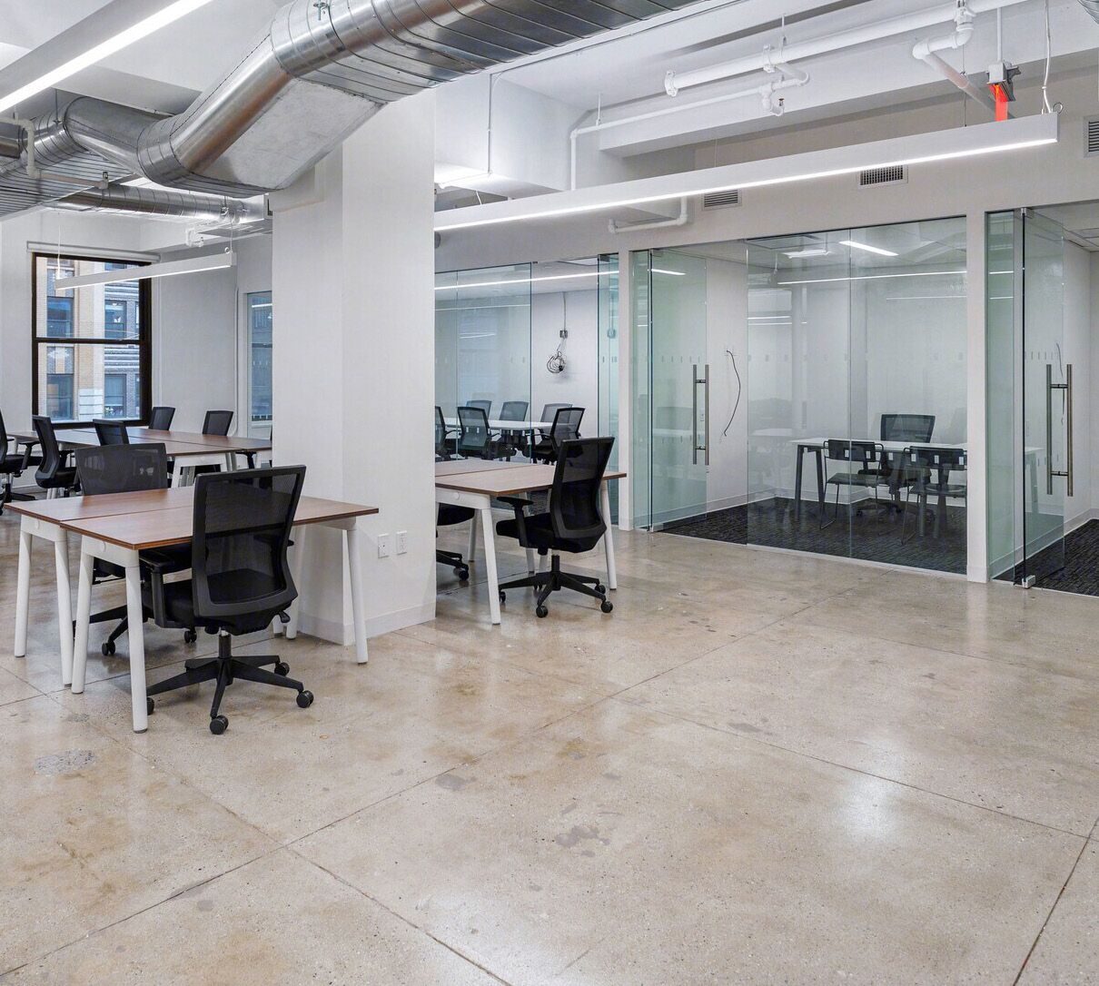Workstations in front of a glass-walled conference room